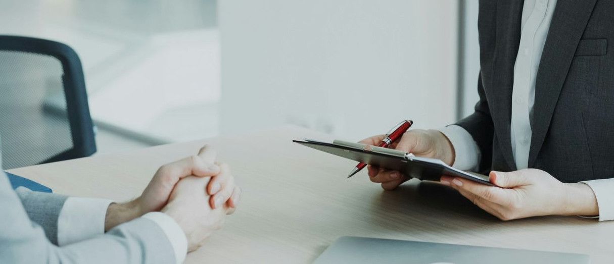 Woman in suit reviews document with man